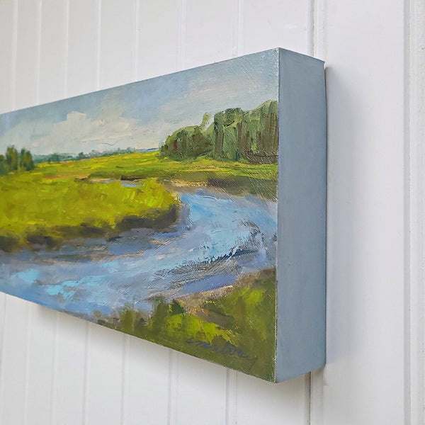 Painting of a landscape with a stream on a white wall